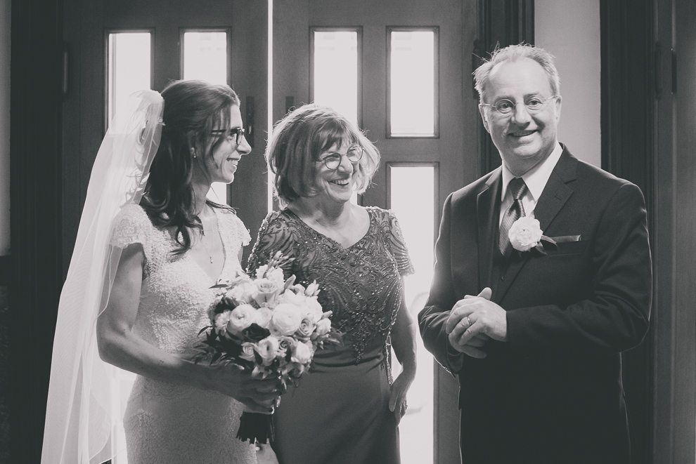 parents and bride smile as they wait together to go down aisle during wedding ceremony at St. Louis Church in Buffalo, NY