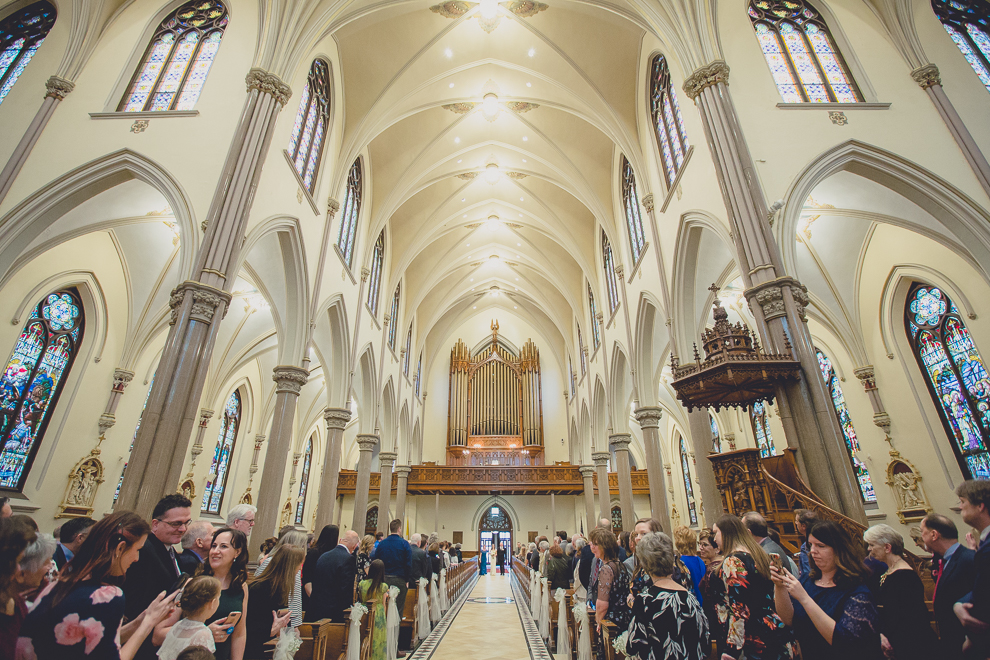 parents of the bride escort her down the aisle during wedding ceremony at St. Louis Church in Buffalo, NY