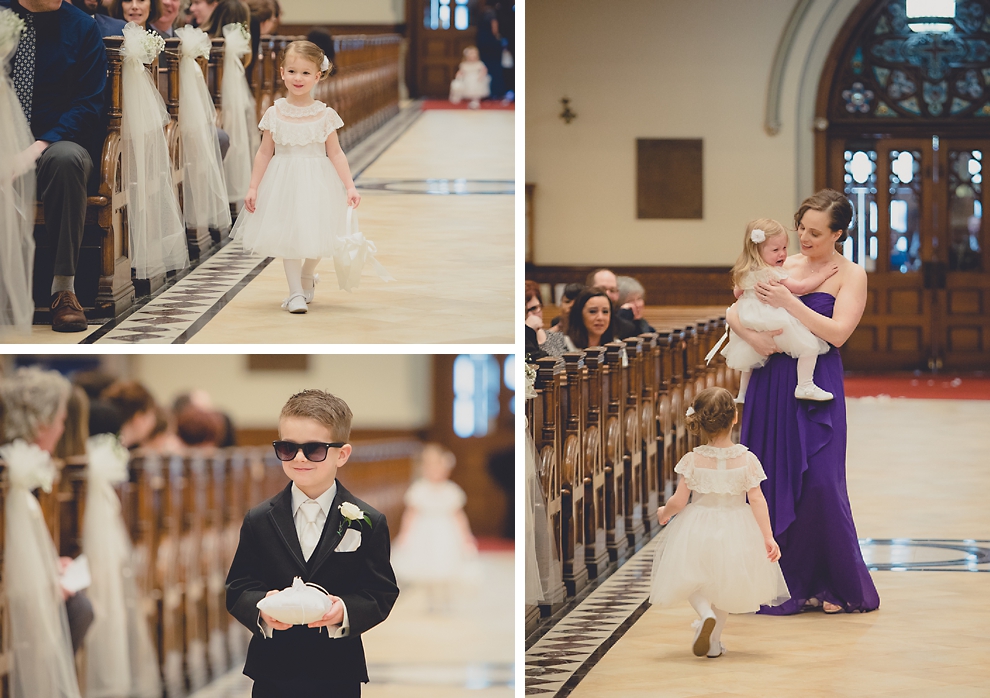 wedding party, flower girls and ring bearer walk down aisle during wedding ceremony at St. Louis Church in Buffalo, NY