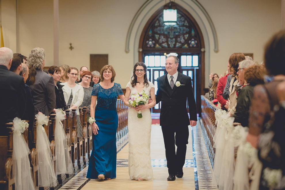 parents of the bride escort her down the aisle during wedding ceremony at St. Louis Church in Buffalo, NY