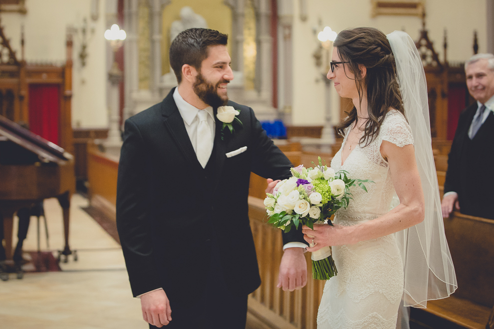 bride and groom smile at each other during wedding ceremony at St. Louis Church in Buffalo, NY