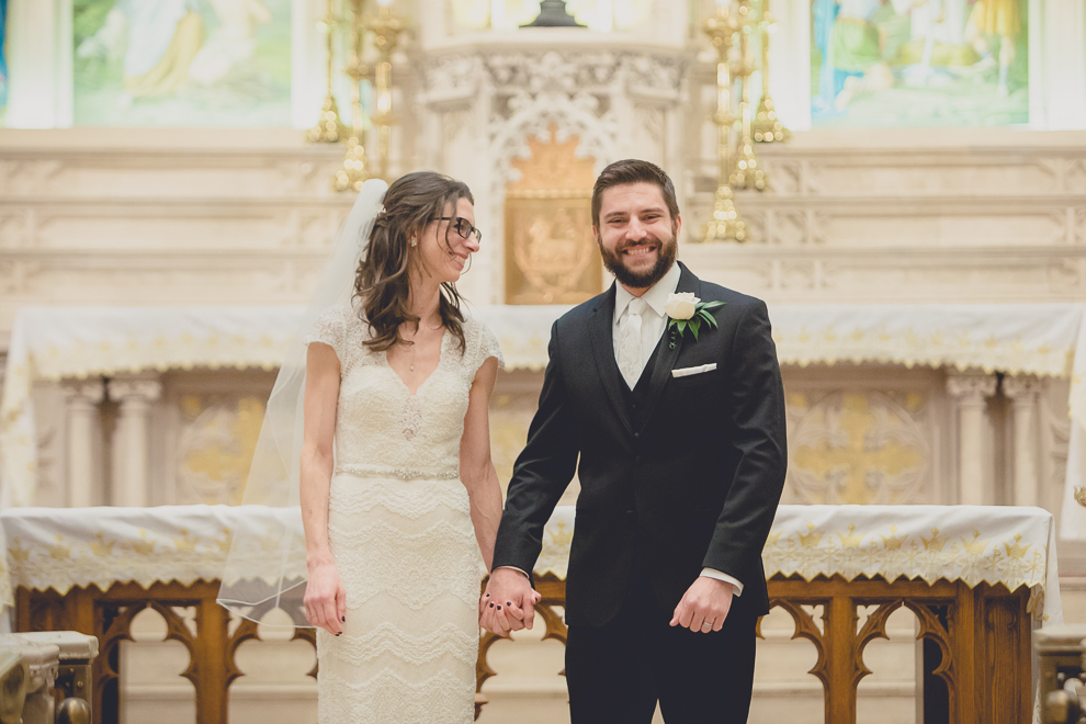 bride and groom smile at each other during wedding ceremony at St. Louis Church in Buffalo, NY