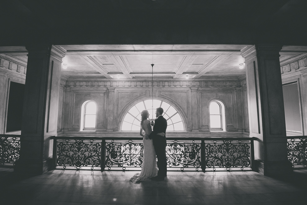 bride and groom pose for portrait at Ellicott Square Building during wedding in Buffalo, NY