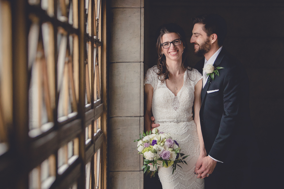 bride and groom pose for portrait at Ellicott Square Building during wedding in Buffalo, NY
