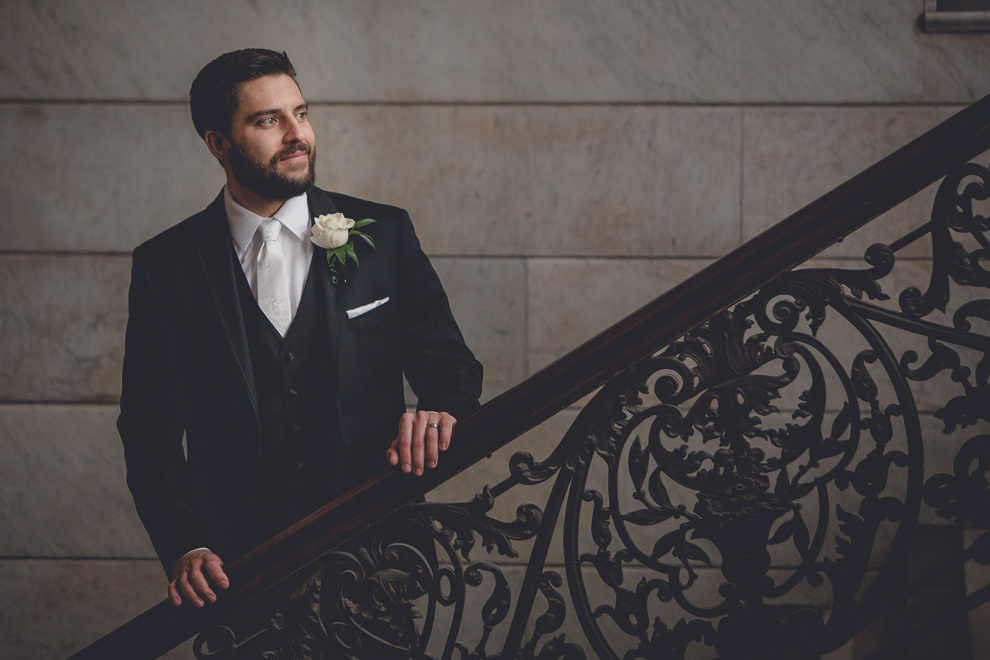 groom poses for portrait at Ellicott Square Building during wedding in Buffalo, NY