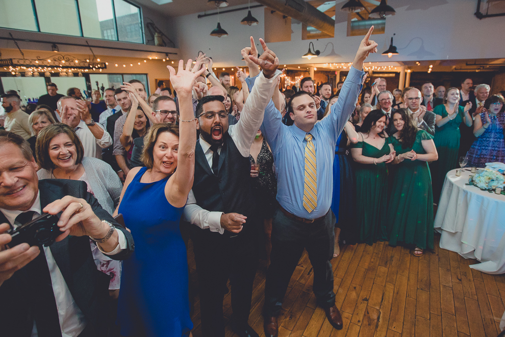 guests cheer for groom who played with James Blonde wedding band groom plays with James Blonde Band during wedding reception in Hotel Lafayette in Buffalo, NY