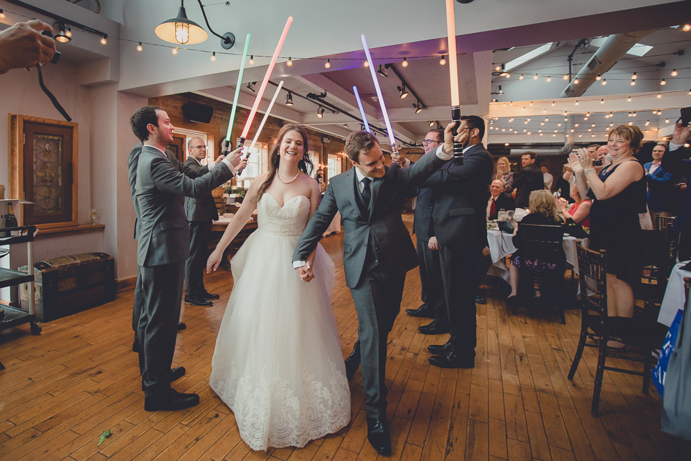 bride and groom are introduced to greenhouse room under light sabres at wedding reception in Hotel Lafayette in Buffalo, NY