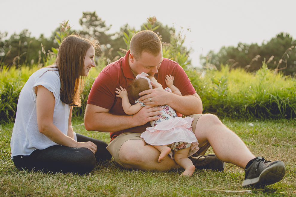 baby hugs dad during family portrait photography session in at Tifft Nature Preserve in Buffalo, NY