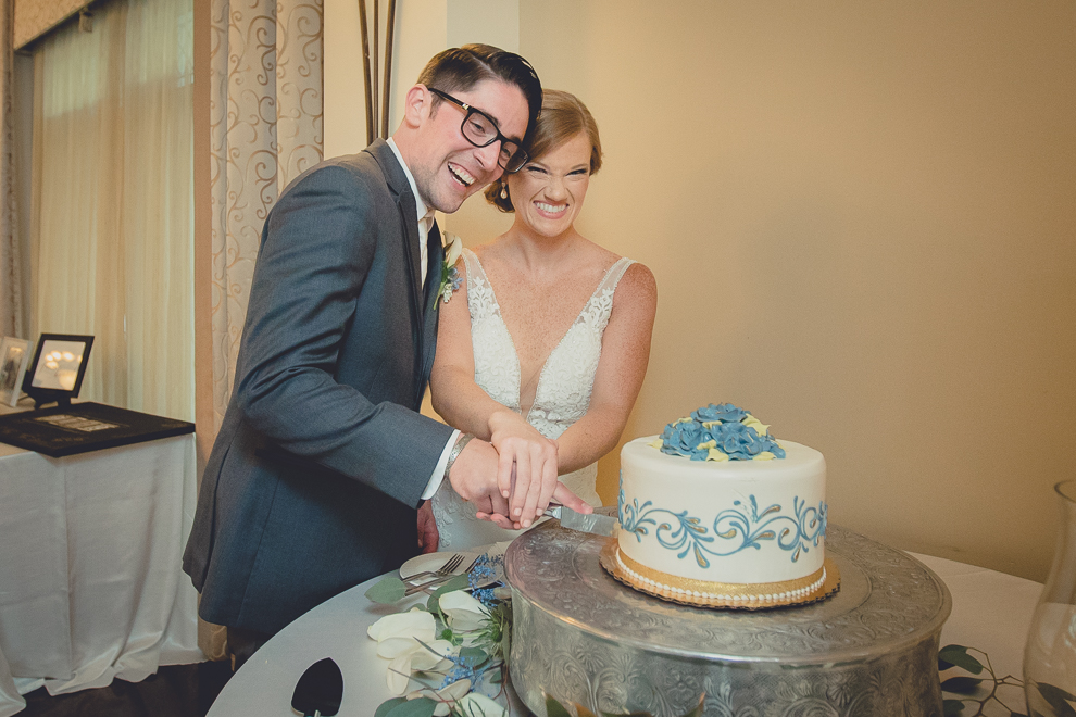 bride and groom cut cake during reception at avanti mansion wedding in Buffalo, NY