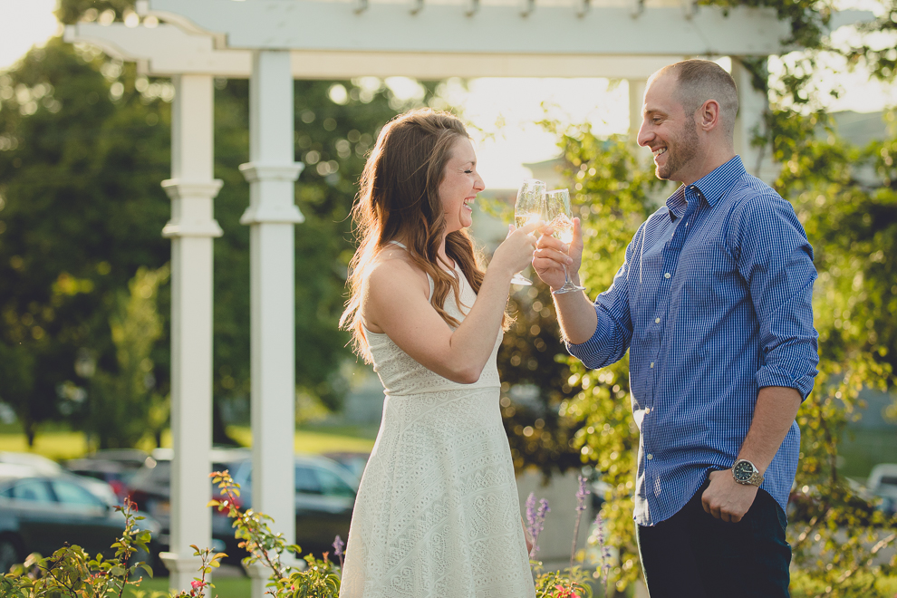 engaged couple has champagne cheers in rose garden for wedding engagement photography at hotel henry & delaware park in Buffalo, NY
