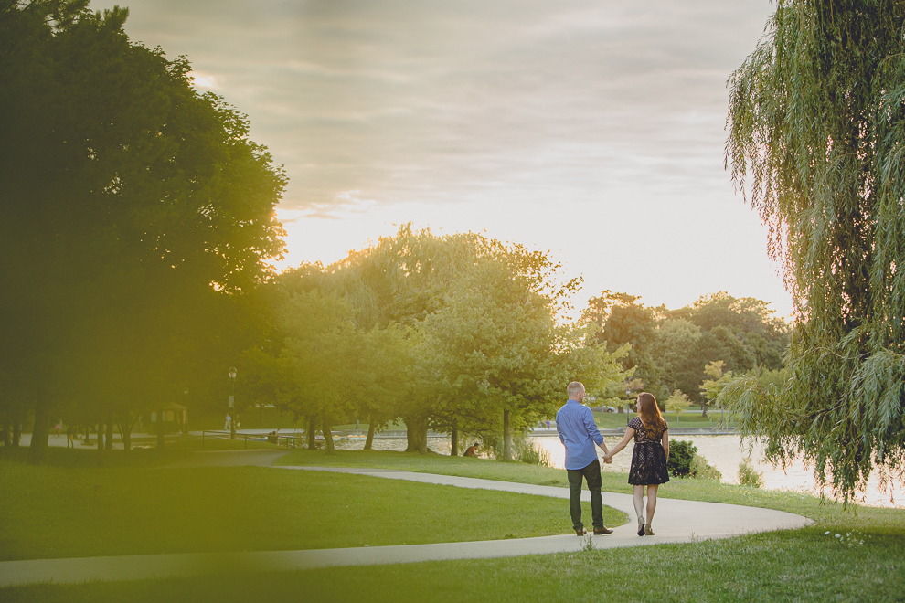 engaged couple walks on path by Hoyt Lake for engagement photography at hotel henry & delaware park in Buffalo, NY