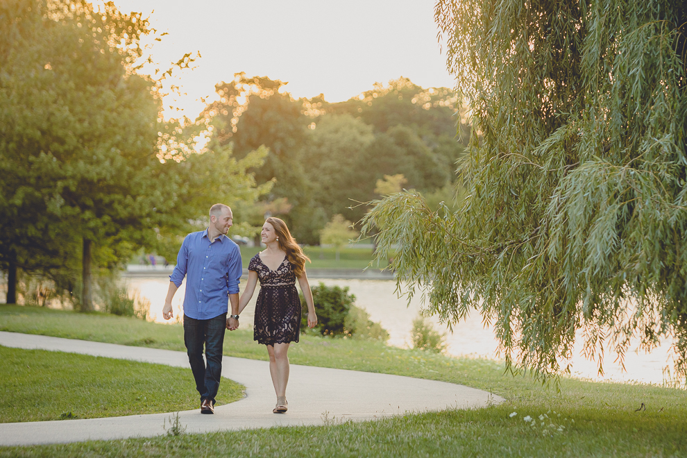 engaged couple walks on path by Hoyt Lake for engagement photography at hotel henry & delaware park in Buffalo, NY