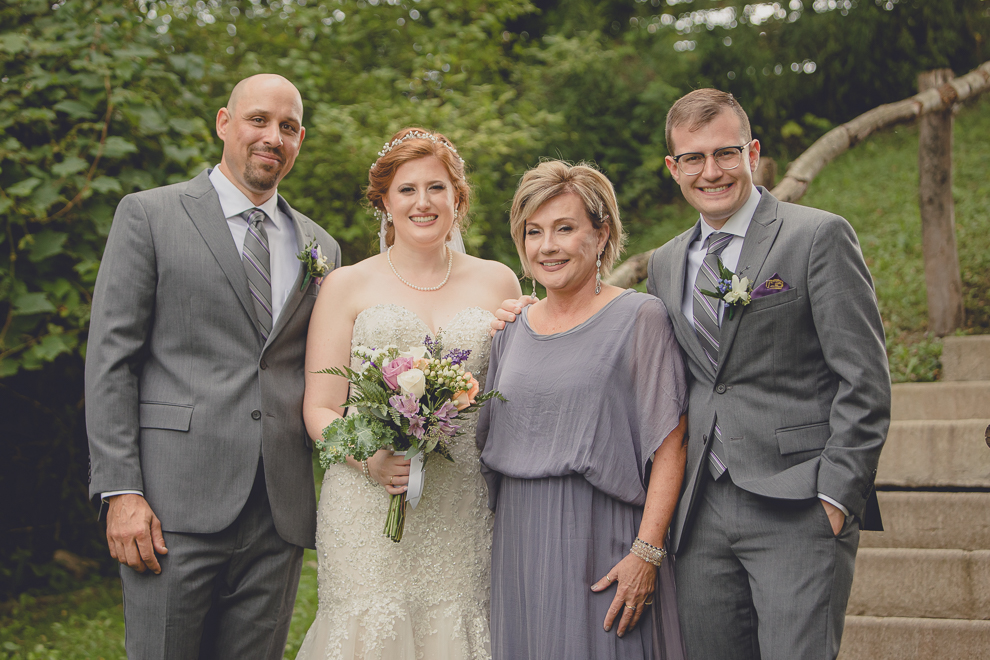family poses for portraits at sunken pond at a Hayloft in the Grove in East Aurora, near Buffalo, NY
