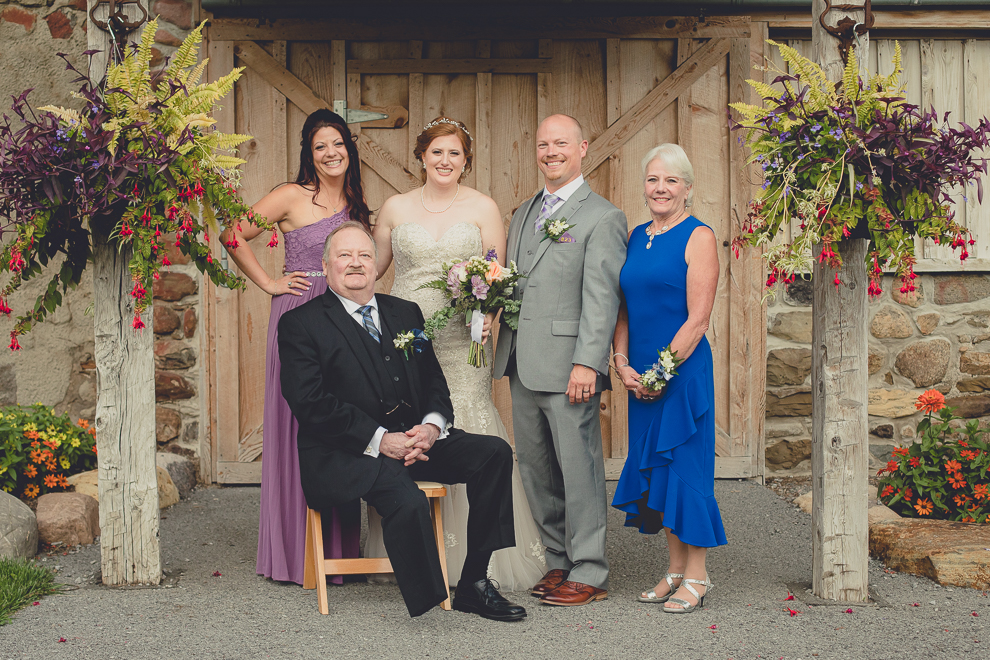 family poses for portraits at sunken pond at a Hayloft in the Grove in East Aurora, near Buffalo, NY
