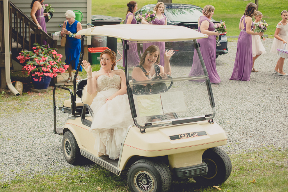 bride riding golf cart from cottage at a Hayloft in the Grove wedding in East Aurora, near Buffalo, NY