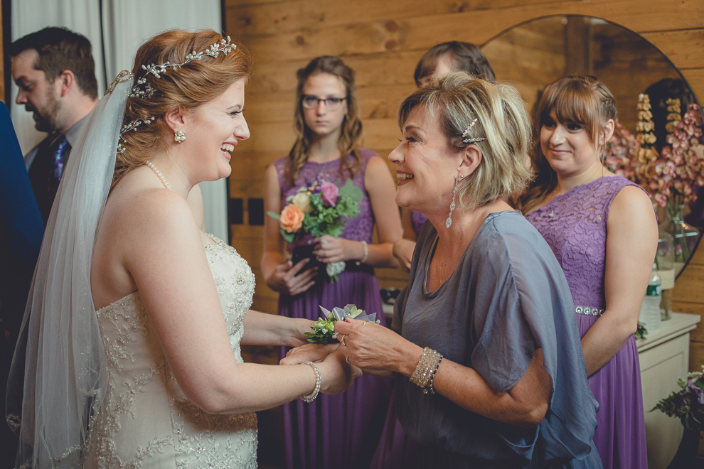 bride and mom laughing at wedding ceremony in converted stables at a Hayloft in the Grove wedding in East Aurora, near Buffalo, NY