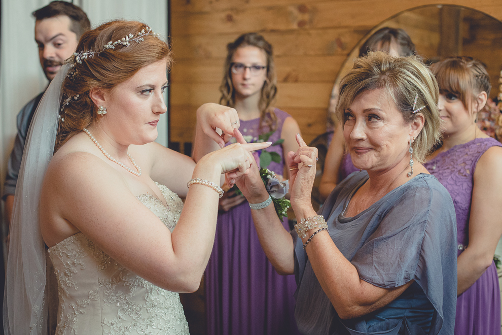 bride and mom laughing at wedding ceremony in converted stables at a Hayloft in the Grove wedding in East Aurora, near Buffalo, NY