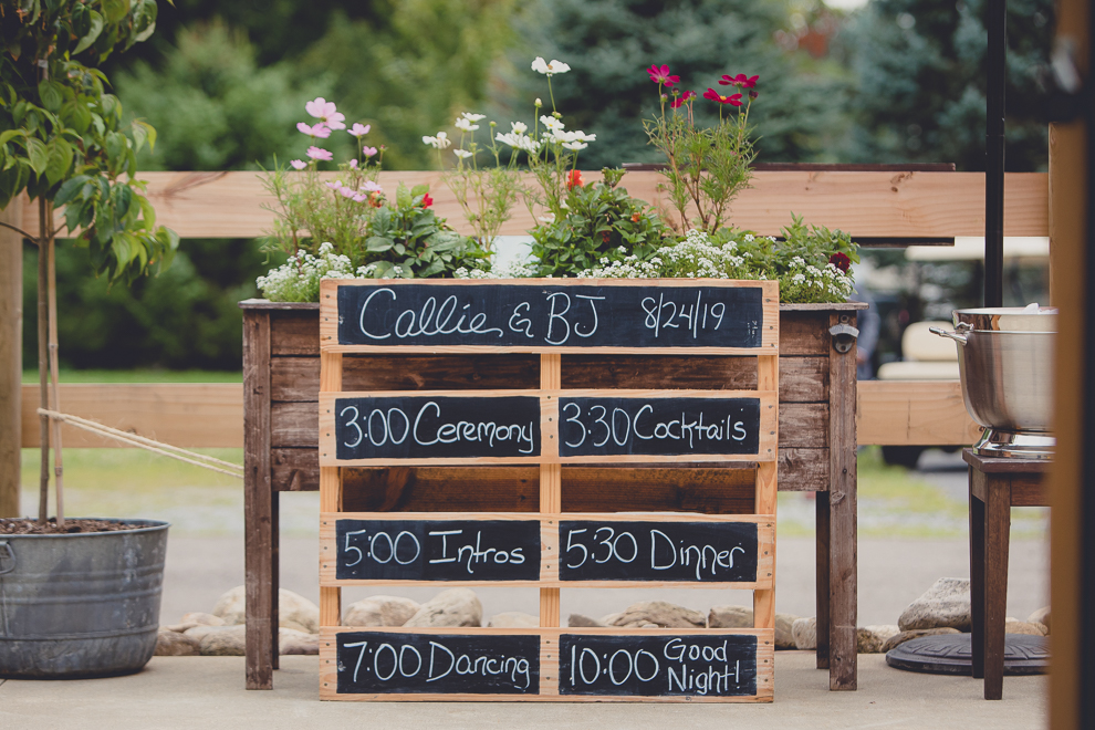 timeline chalkboard sign at wedding ceremony in converted stables at a Hayloft in the Grove wedding in East Aurora, near Buffalo, NY