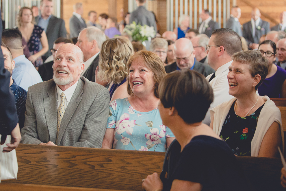 guests laughing at wedding ceremony in converted stables at a Hayloft in the Grove wedding in East Aurora, near Buffalo, NY