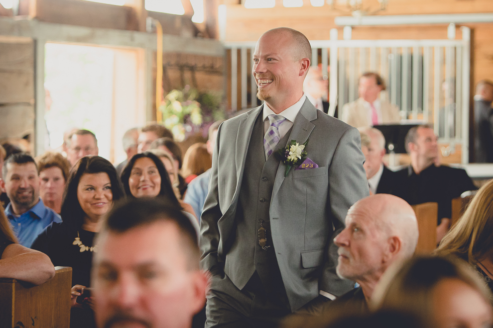 groom laughing at wedding ceremony in converted stables at a Hayloft in the Grove wedding in East Aurora, near Buffalo, NY