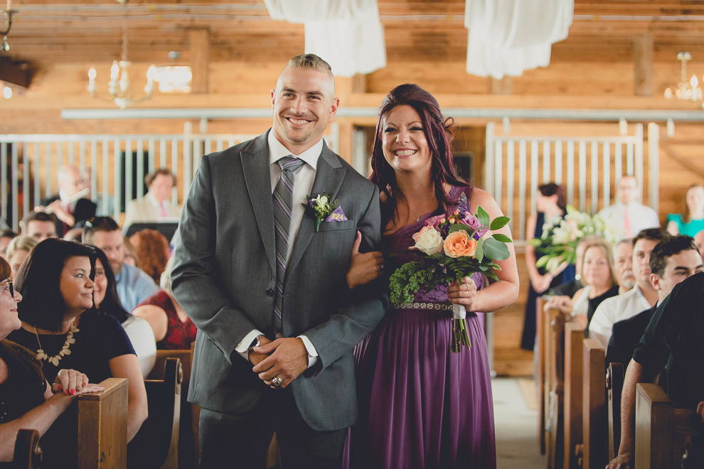 wedding party laughs at wedding ceremony in converted stables at a Hayloft in the Grove wedding in East Aurora, near Buffalo, NY