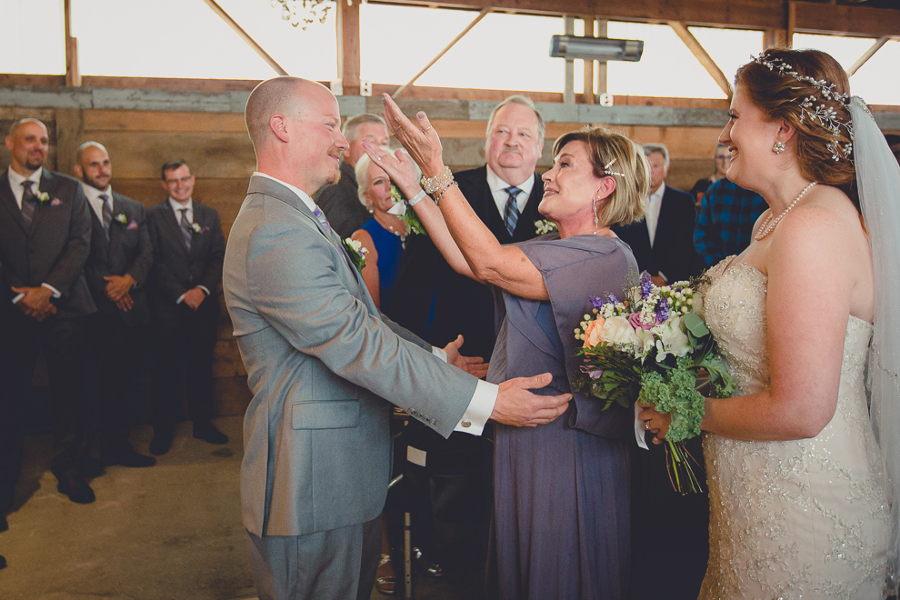 groom and mom hug at wedding ceremony in converted stables at a Hayloft in the Grove wedding in East Aurora, near Buffalo, NY