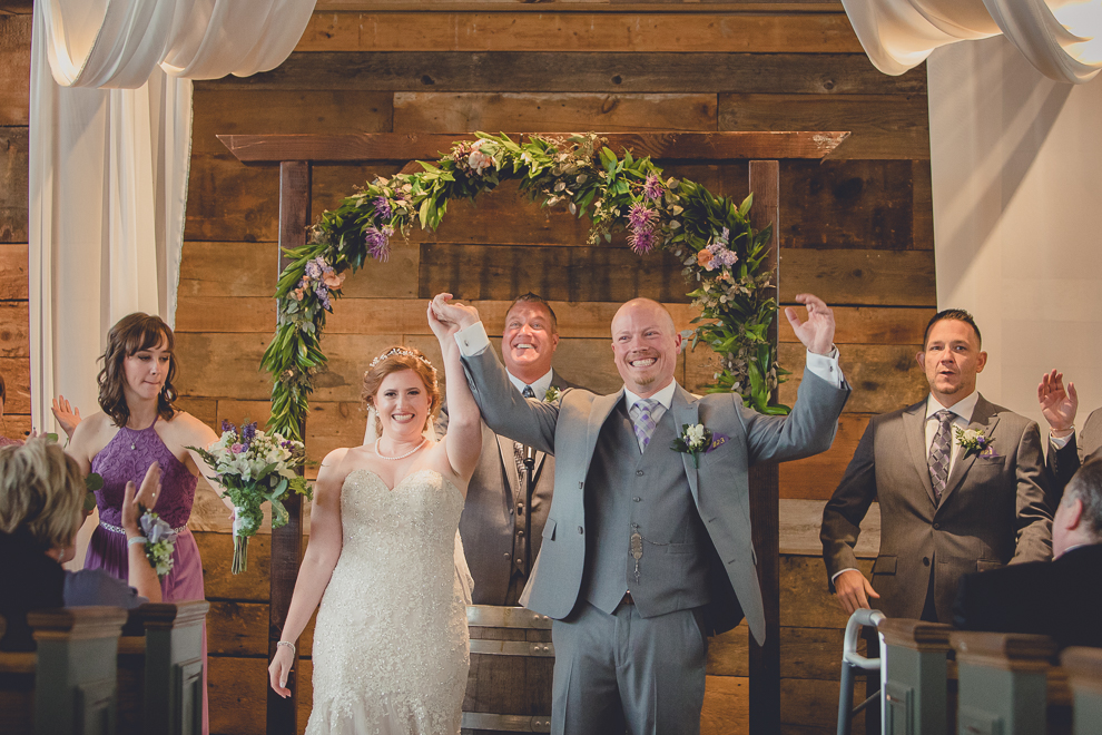 bride and groom cheer at wedding ceremony in converted stables at a Hayloft in the Grove in East Aurora, near Buffalo, NY