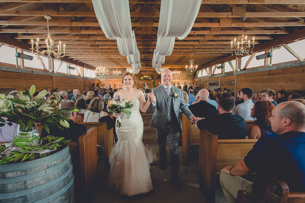 bride and groom walk down aisle at wedding ceremony in converted stables at a Hayloft in the Grove in East Aurora, near Buffalo, NY