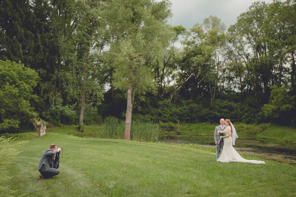 bride and groom pose for portraits at sunken pond at a Hayloft in the Grove in East Aurora, near Buffalo, NY