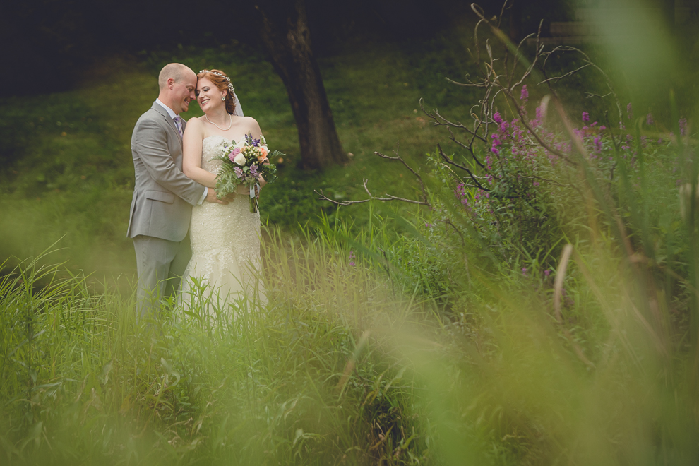 bride and groom pose for portraits at sunken pond at a Hayloft in the Grove in East Aurora, near Buffalo, NY