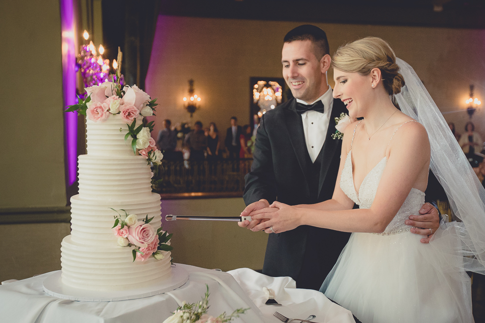 groom and bride cut cake in Terrace Room at the Statler City wedding reception venue in Buffalo, NY