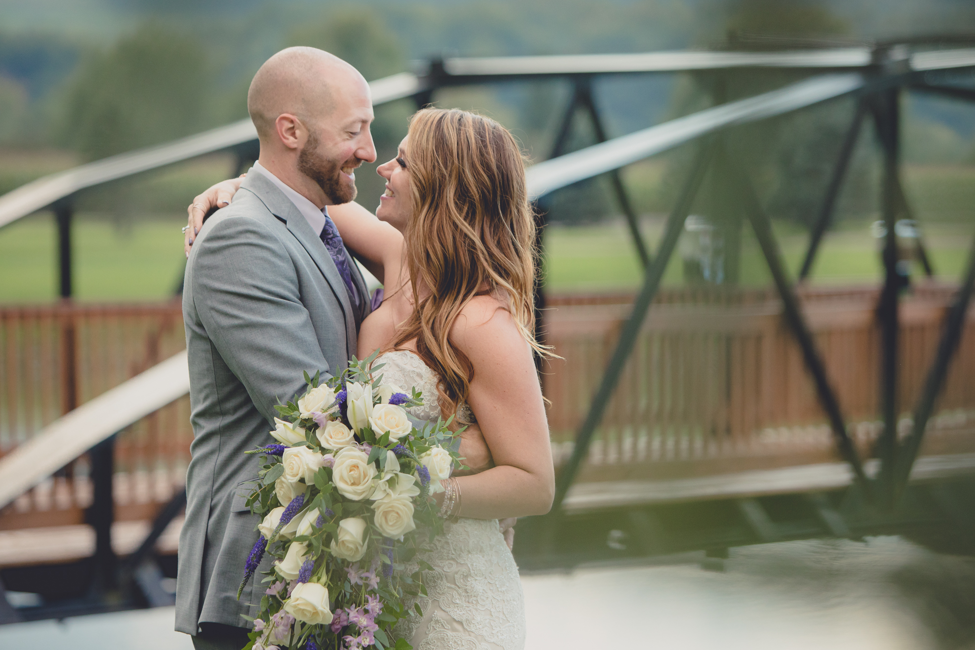 bride and groom pose for wedding portraits in rain at their wedding at hidden valley animal adventure near Buffalo, NY