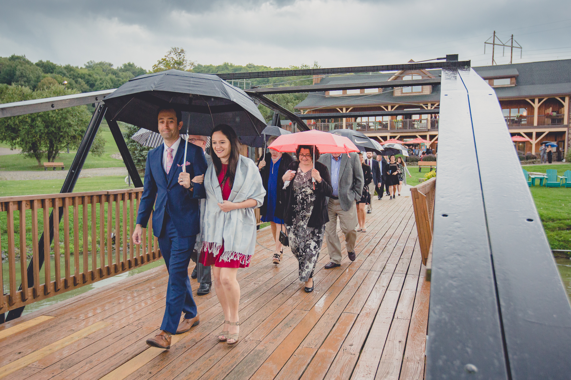 guests hold colorful umbrellas during wedding ceremony at hidden valley animal adventure near Buffalo, NY