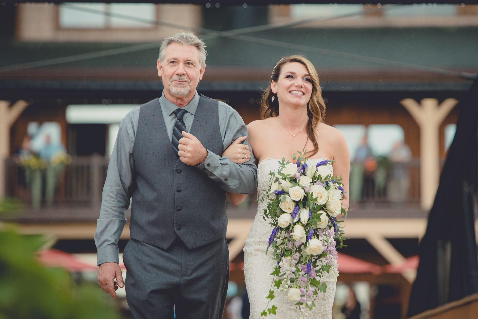 brides walks down the aisle with her father during wedding ceremony at hidden valley animal adventure near Buffalo, NY