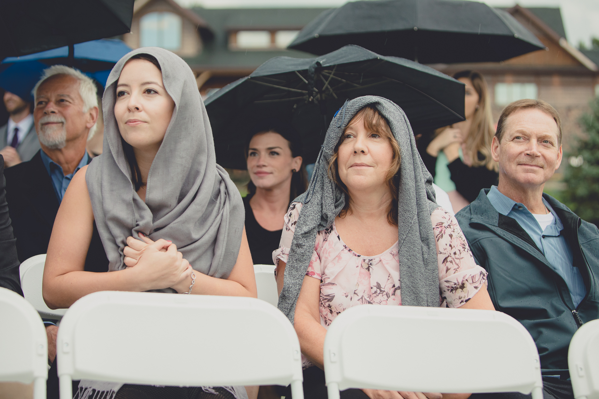 guests hold colorful umbrellas during wedding ceremony at hidden valley animal adventure near Buffalo, NY