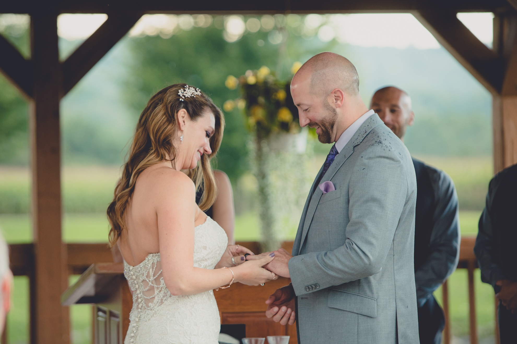 photography of bride and groom exchanging rings at wedding ceremony at hidden valley animal adventure near Buffalo, NY