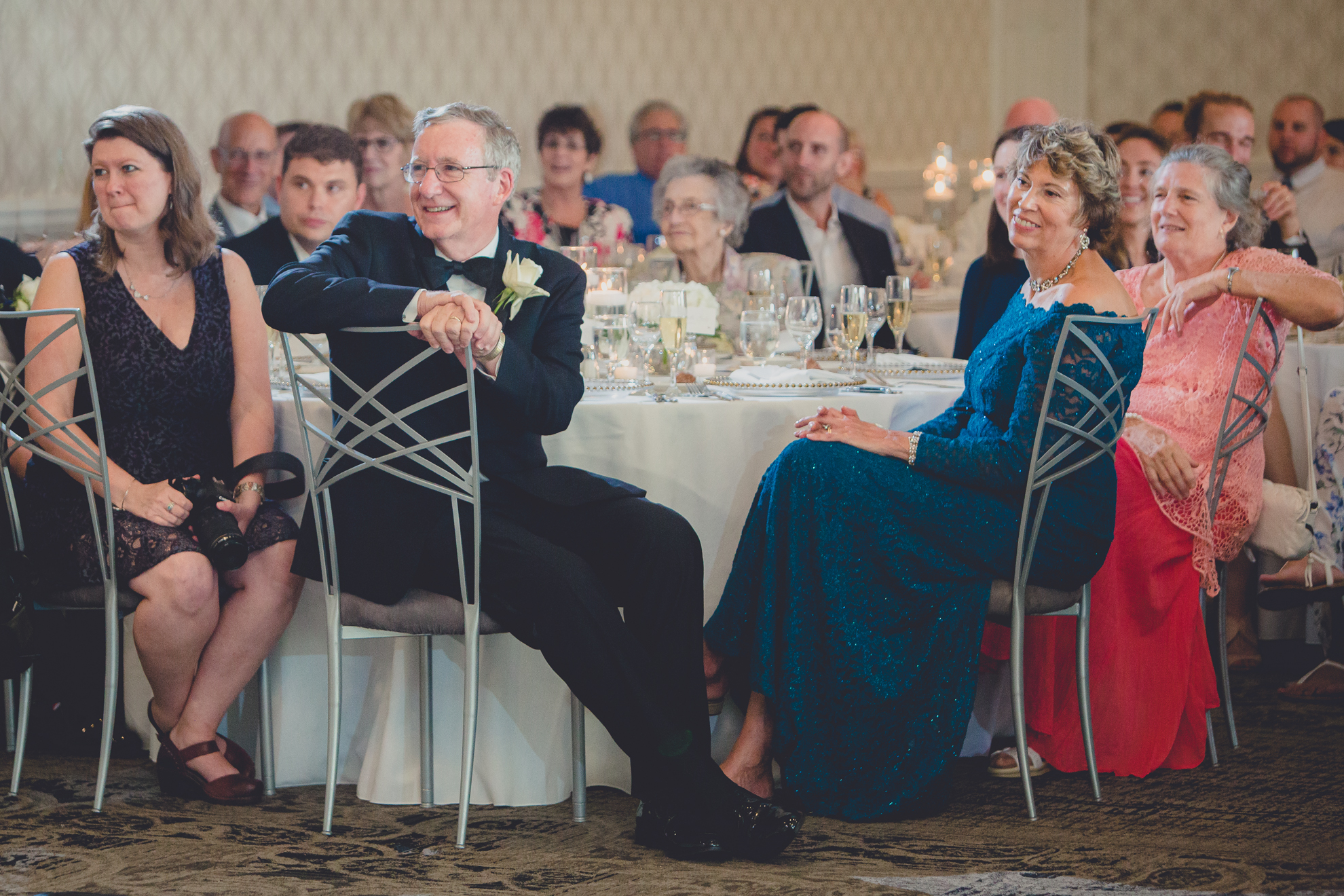 parents smile during speech at wedding reception at Niagara Falls Country Club in Lewiston, NY