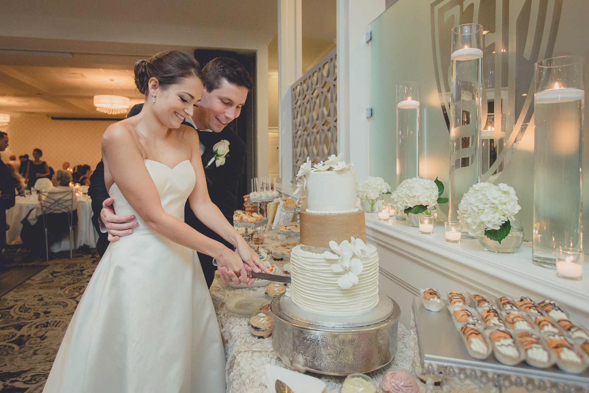 bride and groom cut cake at wedding reception at Niagara Falls Country Club in Lewiston, NY