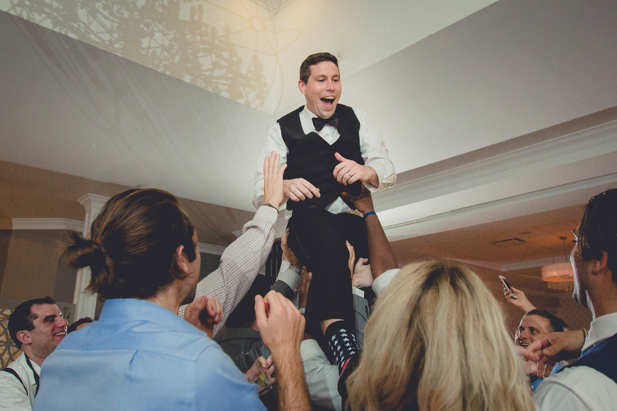 guests lift groom above their heads at wedding reception at Niagara Falls Country Club in Lewiston, NY