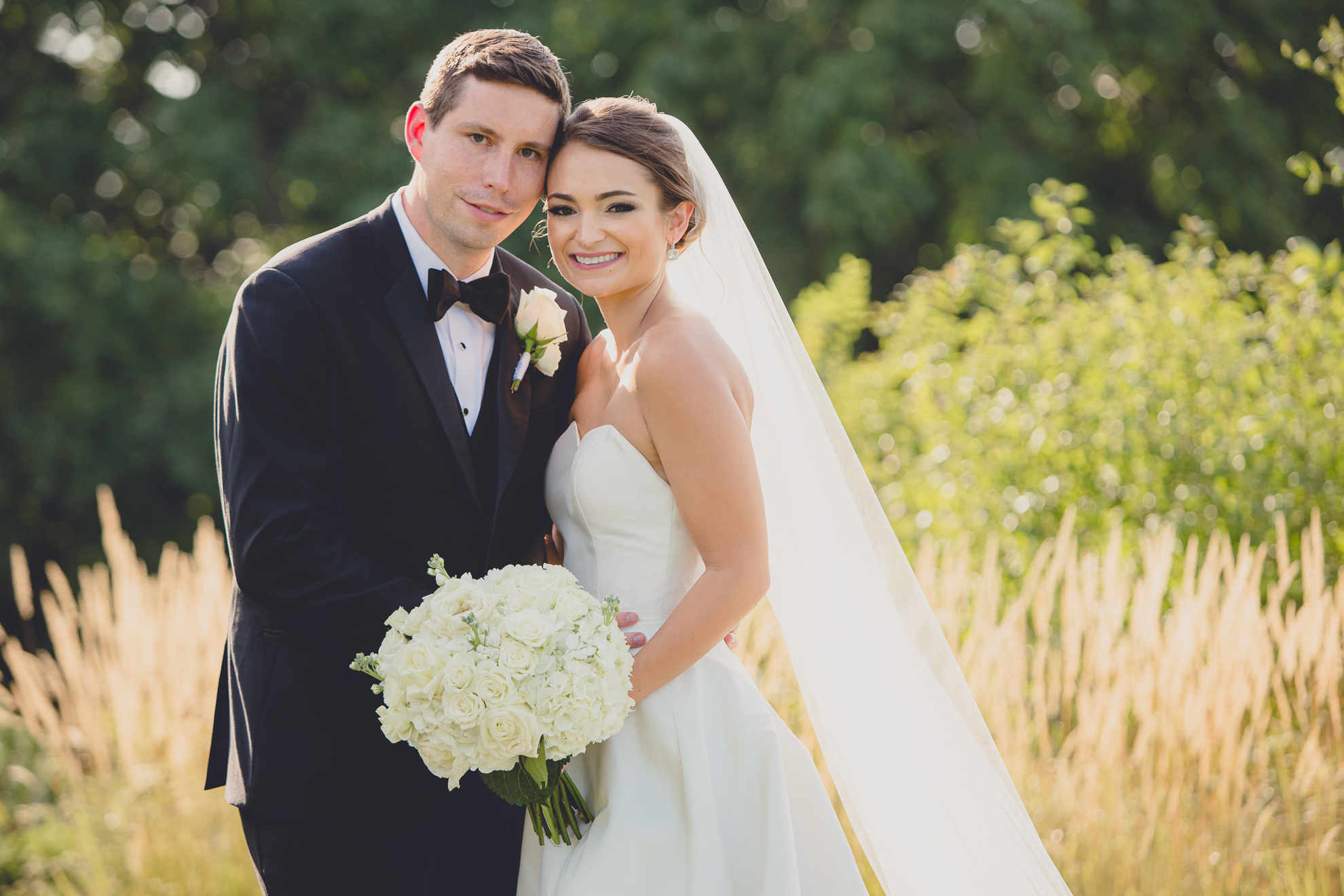 bride and groom smile for photographer before wedding reception at Niagara Falls Country Club near Buffalo, NY