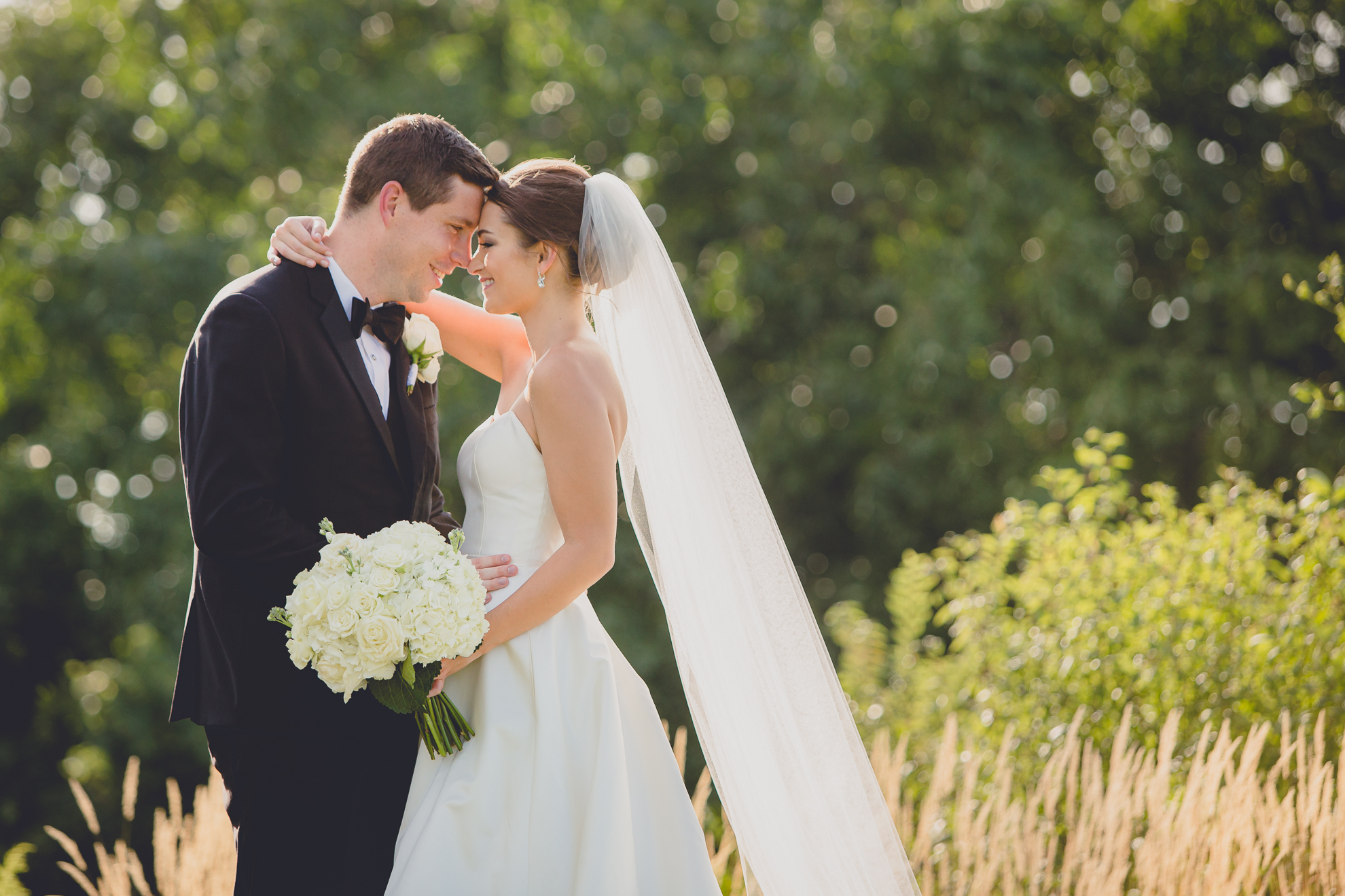 portrait of bride and groom touching noses before wedding reception at Niagara Falls Country Club near Buffalo, NY