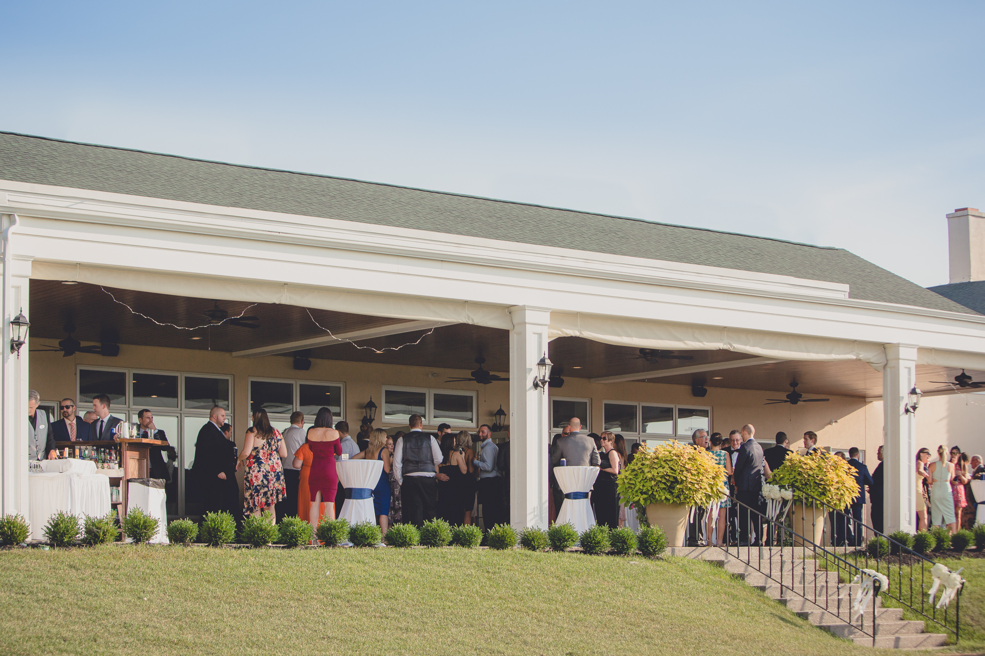 guest gather on patio during cocktail hour of wedding reception at Niagara Falls Country Club in Lewiston, NY