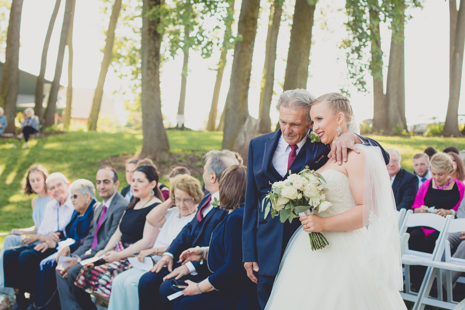 father and bride embrace after processional at Spring Lake Winery in Niagara County before wedding near Buffalo, NY