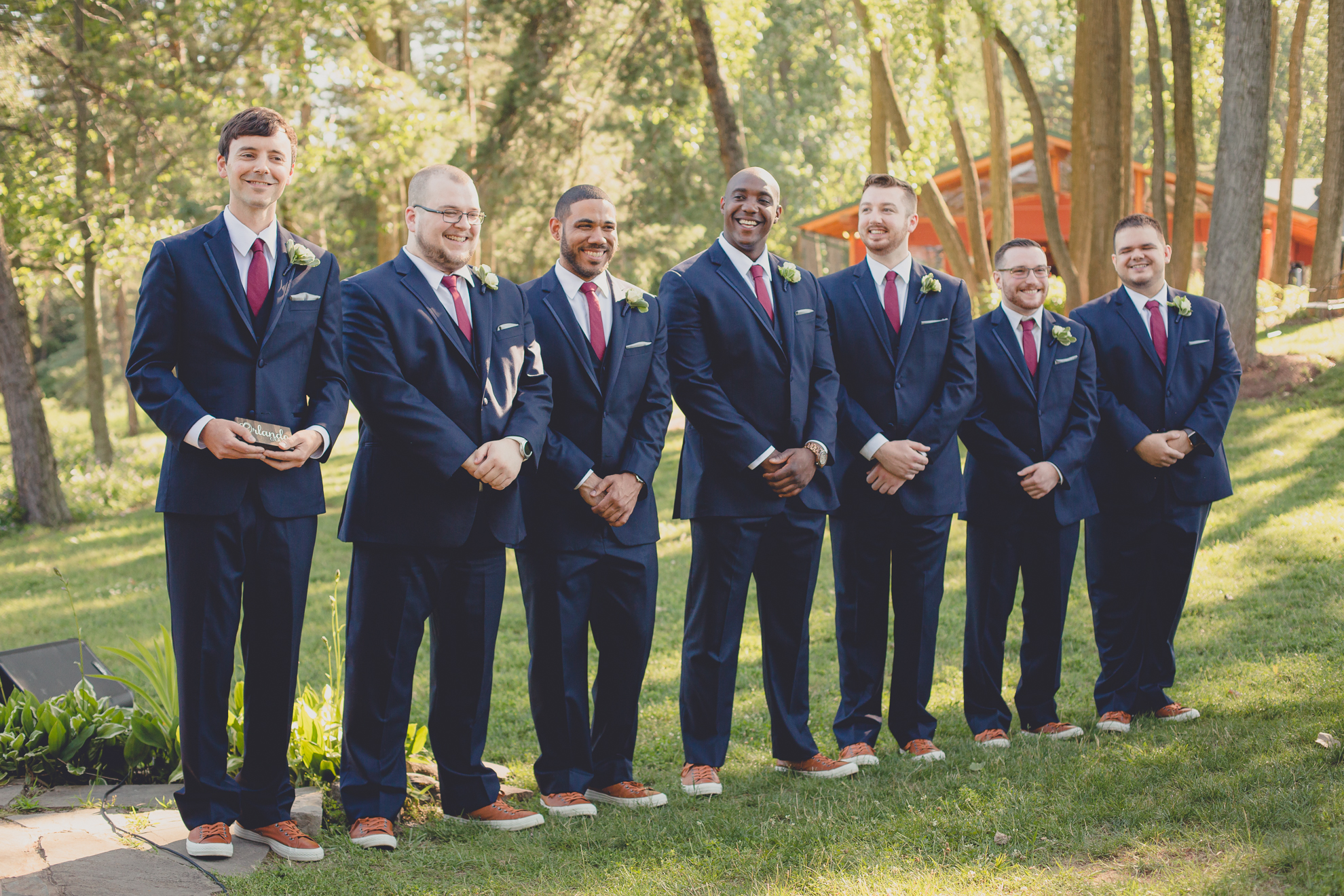 groomsmen smile as bride walks down aisle at Spring Lake Winery in Niagara County before wedding near Buffalo, NY
