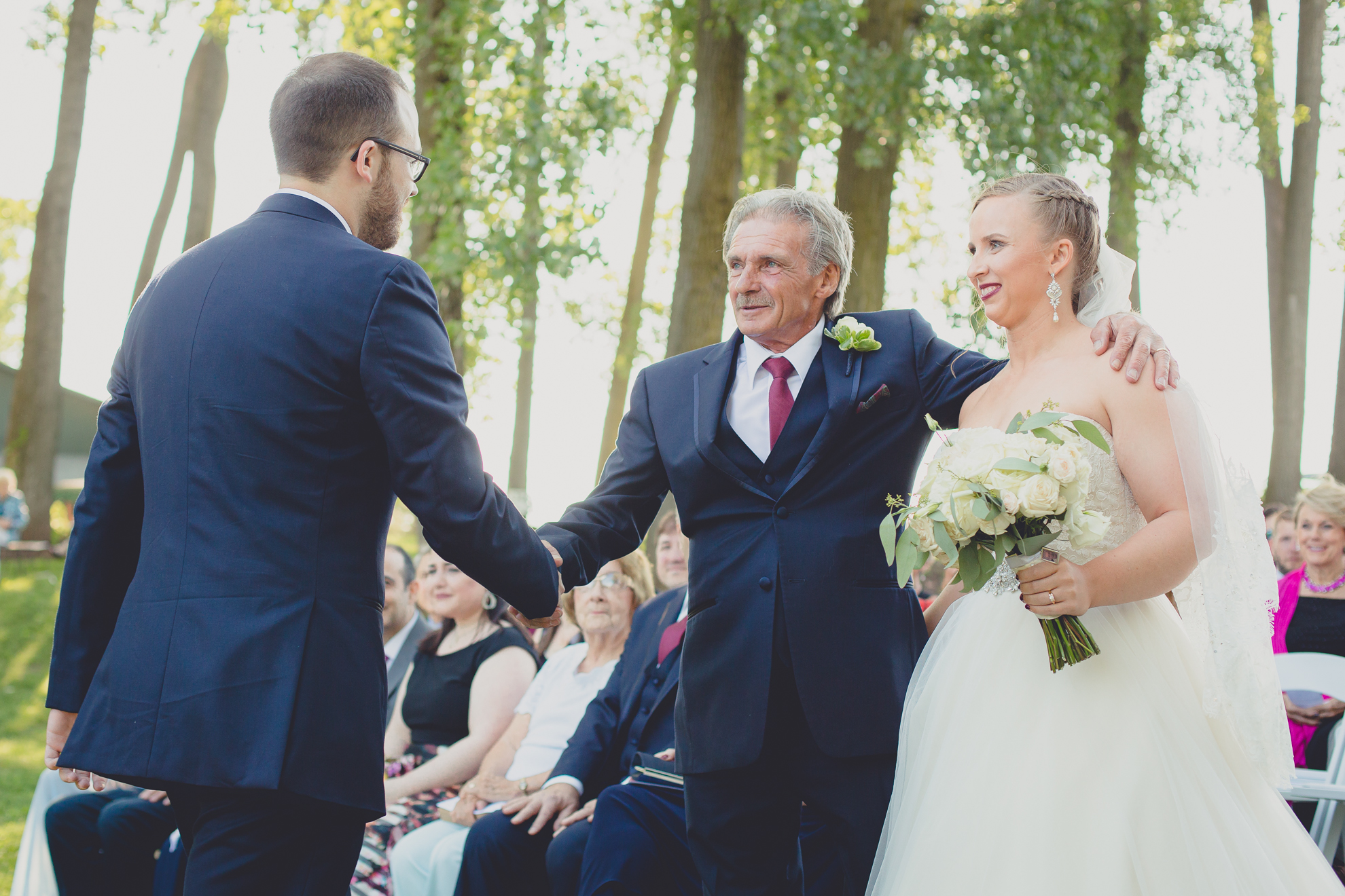father shakes grooms hand after processional at Spring Lake Winery in Niagara County before wedding near Buffalo, NY
