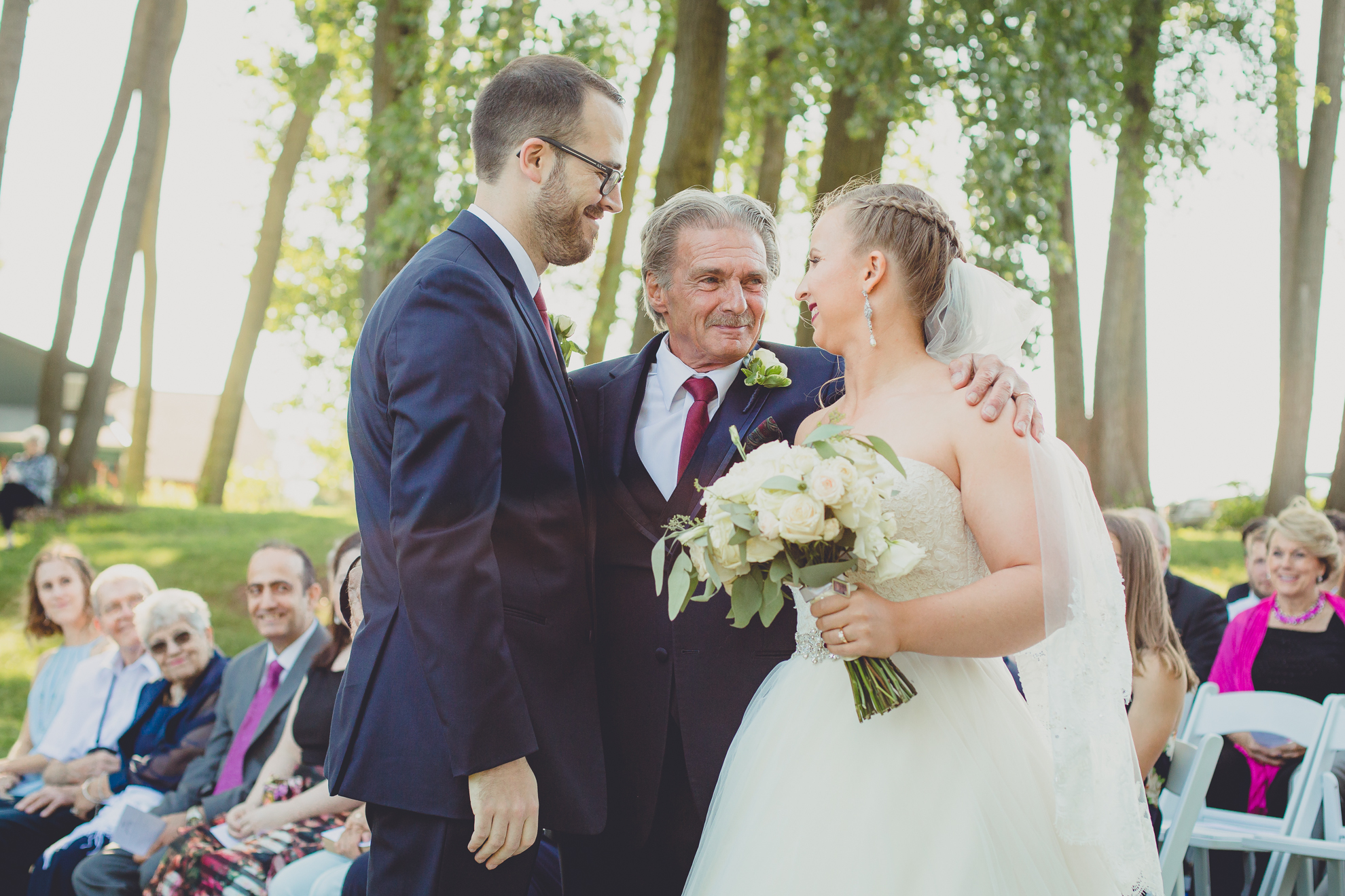 father looks at bride after processional at Spring Lake Winery in Niagara County before wedding near Buffalo, NY