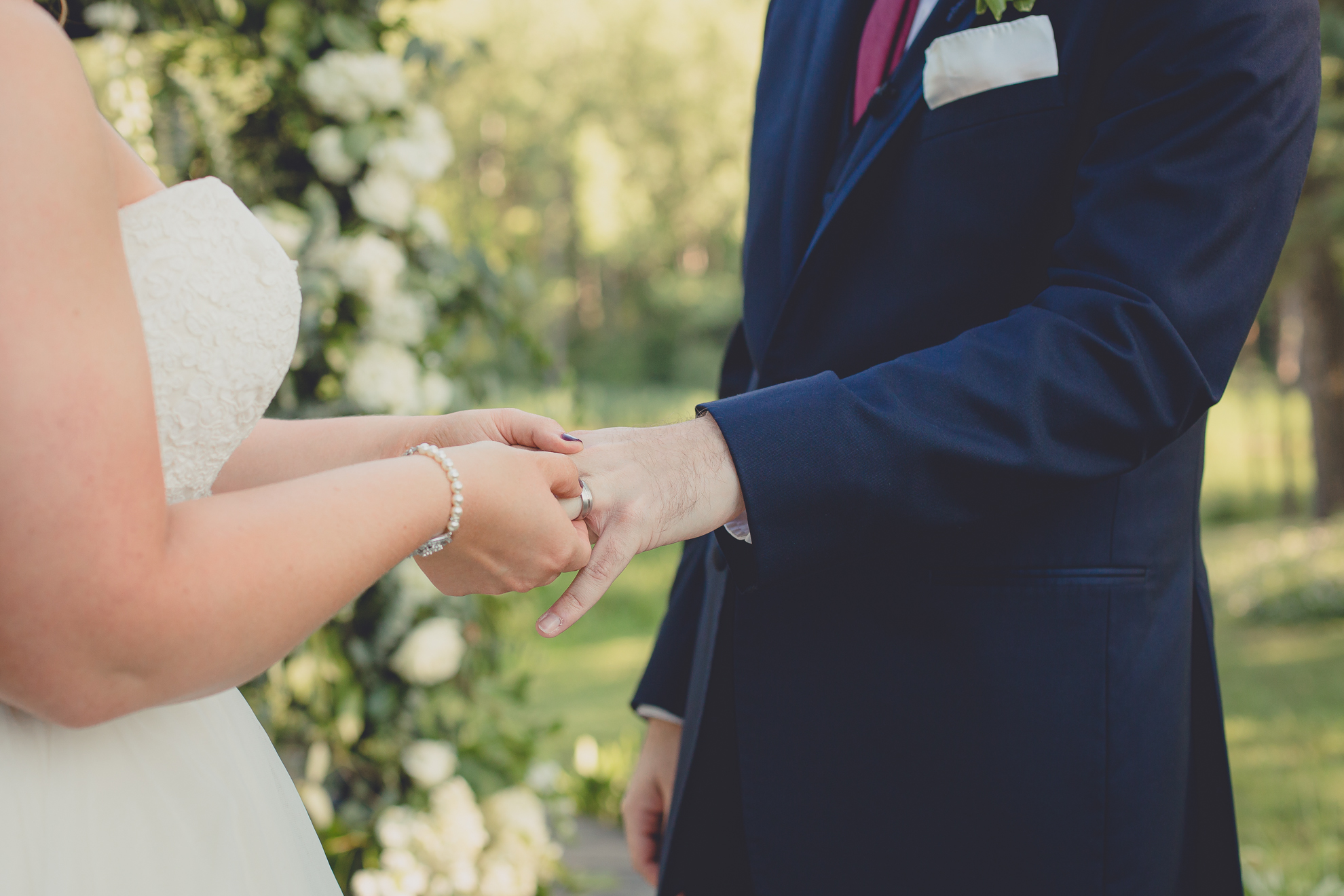bride and groom exchange rings during wedding outdoor wedding ceremony at Spring Lake Winery in Lockport, NY