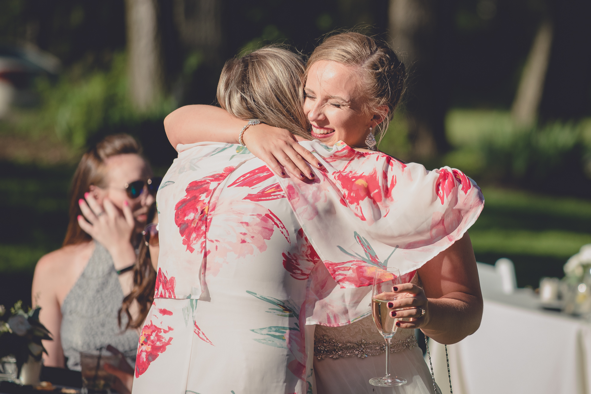 bride hugs guest during outdoor wedding reception at Spring Lake Winery near Buffalo in WNY