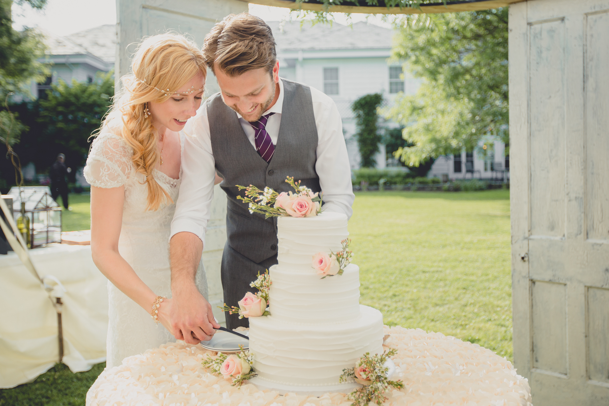 bride and groom cut cake under tent at reception at small wedding at Knox Farm near Buffalo, NY