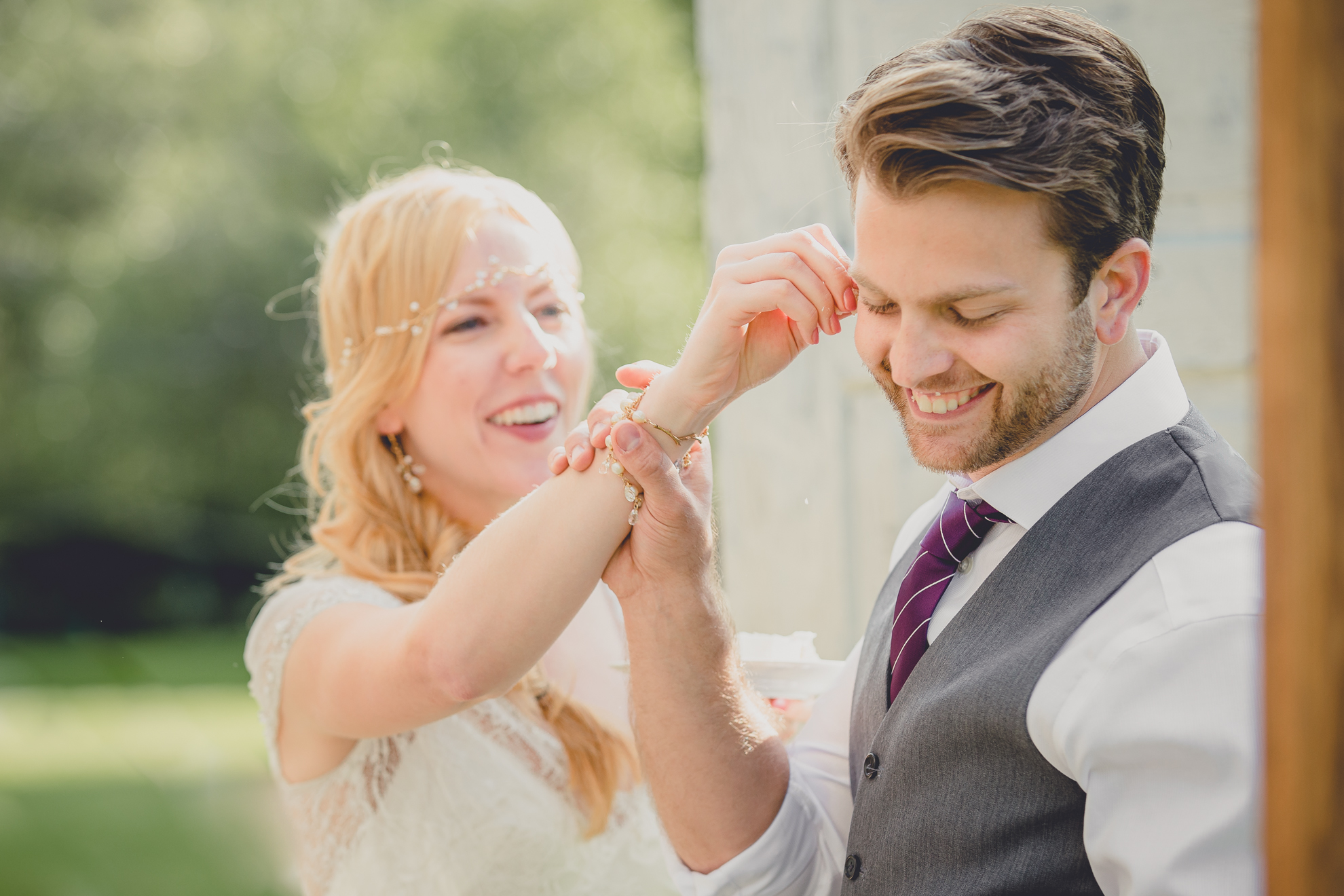 bride and groom feed each other cake under tent at reception at wedding at Knox Farm near Buffalo, NY